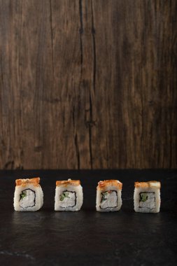 Siyah yüzeyde dört parça ejderha suşi.