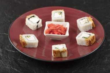 Kırmızı tabakta yılan balığı ve zencefil turşulu lezzetli ejderha suşisi.