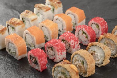 Siyah yüzeyde lezzetli taze suşi ruloları.