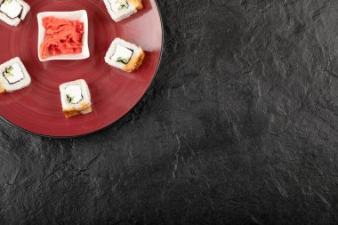 Kırmızı tabakta yılan balığı ve zencefil turşulu lezzetli ejderha suşisi.