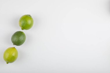 Beyaz arka planda üç olgun kireç meyvesi