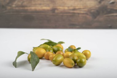 Beyaz arka planda yaprakları olan taze olgun kumkatlar.