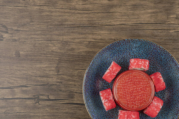 Чаша суши и красная икра на деревянном столе