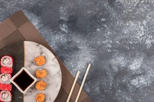Två sorters goda sushirullar och sojasås på marmorplatta — Stockfoto