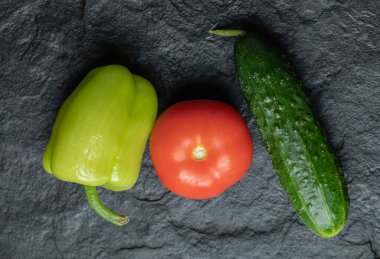 Siyah arka planda taze organik sebzelerin yakın plan fotoğrafı.