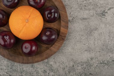 Sağlıklı portakallı taze mor erik tabağı.