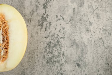 Yarım dilimlenmiş sarı kavun mermer yüzeyde