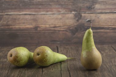 Tahta yüzeye üç taze armut yerleştirildi.