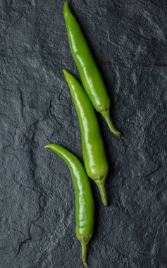 Dikey fotoğraf. Yeşil acı biberlerin yakın çekimi