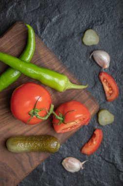 Tahta üzerinde taze sebze ve turşunun dikey fotoğrafı.