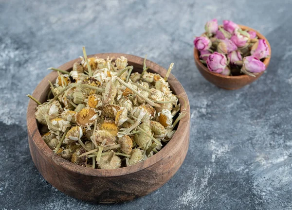 Getrocknete Rosenblätter und Kamillen in Holzschalen — Stockfoto