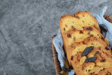 Sultana turtası, altında mavi havluyla ahşap bir sepette dilimler.