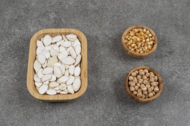 Lezzetli balkabağı tohumları, mısır taneleri ve mermer arka planda bezelyeler. Yüksek kalite fotoğraf