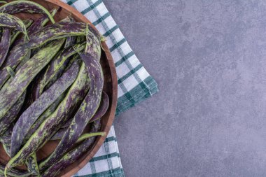 Mavi arka plandaki ahşap tepside izole edilmiş yeşil fasulyeler. Yüksek kalite fotoğraf