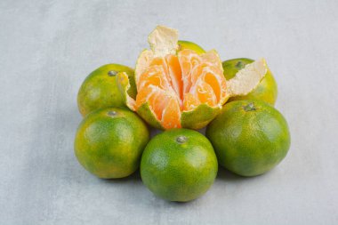 Taş zeminde soyulmuş ve soyulmamış taze mandalinalar. Yüksek kalite fotoğraf