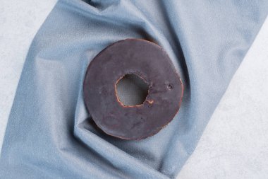 Mermer arka planda masa örtüsü üzerine çikolata kaplı küçük bir pasta. Yüksek kalite fotoğraf