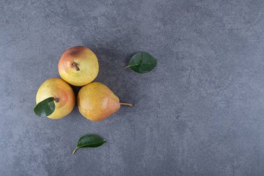 Gri arka planda yaprakları olan taze organik armutların üst görüntüsü. Yüksek kalite fotoğraf