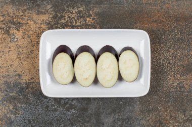 Tabakta dört parça patlıcan var, mermer arka planda. Yüksek kalite fotoğraf