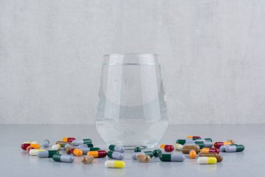 Çeşitli ilaç kapsülleri ve bir bardak su. Yüksek kalite fotoğraf