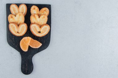 Mermer zemin üzerinde siyah bir tahtada pullu kurabiyeler ve kılıçbalığı. Yüksek kalite fotoğraf