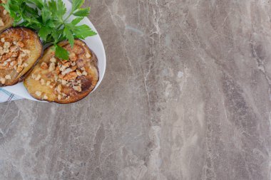 Kızarmış Hint patlıcan dilimleri, doğranmış sarımsak ve maydanozla süslenmiş, mermer arka planda. Yüksek kalite fotoğraf