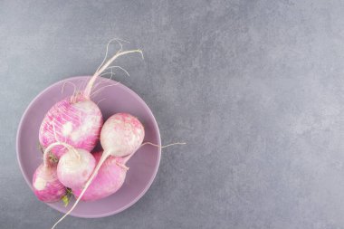 Mermer arka plandaki tabakta taze turplar. Yüksek kalite fotoğraf