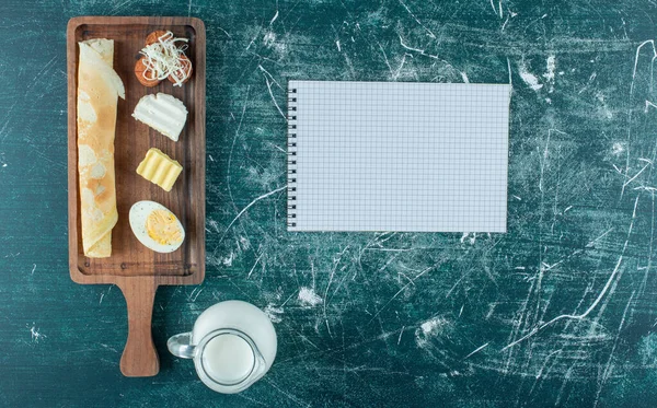 Breakfast board with crepes and a jar of milk. High quality photo