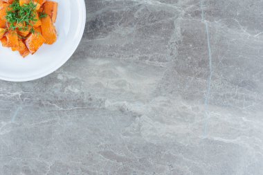 Bir tabak dilimlenmiş havuç, mermer arka planda. Yüksek kalite fotoğraf