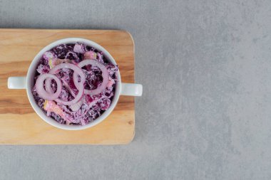 Beton arka planda seramik bir fincanda mor soğan salatası. Yüksek kalite fotoğraf