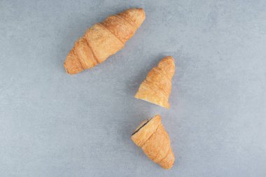 Dilimlenmiş kruvasan ve mermer arka planda tam bir kruvasan. Yüksek kalite fotoğraf