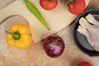 Pişmemiş tavuk bacaklı sebzeler mermer arka planda. Yüksek kalite fotoğraf