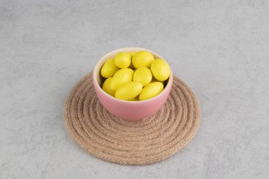 Mermer arka plandaki trivet bardağındaki sarı şekerler. Yüksek kalite fotoğraf