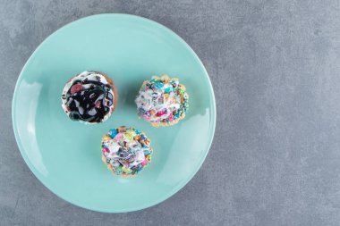 Üç tatlı kekten oluşan mavi bir tabak. Yüksek kalite fotoğraf