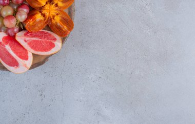 Mermer zemin üzerinde ahşap bir tahtanın üzerinde küçük bir meyve çeşitliliği. Yüksek kalite fotoğraf