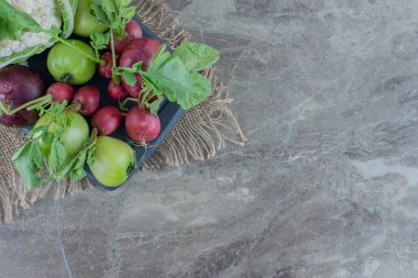 Kırmızı soğanlı donanma tabağı, karnabahar, yeşil domates, şalgam ve mermer zemin üzerinde şalgam yaprakları. Yüksek kalite fotoğraf
