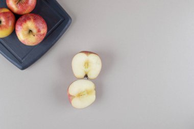 Mermer arka planda dilimlenmiş elmaların yanındaki tahtada tam elma. Yüksek kalite fotoğraf