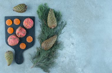 Çam kozalaklarının yanına tatlı tepsisi ve mermer zemin üzerinde bir çam dalı. Yüksek kalite fotoğraf