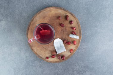 Tahta bir parçanın üzerinde bir bardak gül kalçası çayı. Yüksek kalite fotoğraf