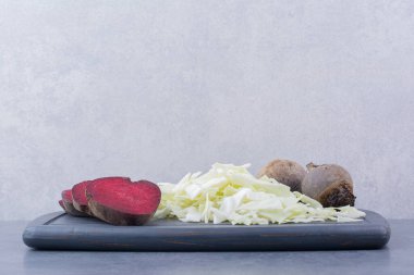 Tahtasında beyaz lahana olan doğranmış pancar kökleri. Yüksek kalite fotoğraf