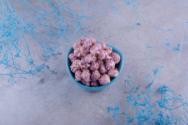 Mermer arka planda mavi dekoratif dalların yanında küçük boy patlamış mısır servisi. Yüksek kalite fotoğraf