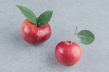 Mermer arka planda iki elma sergileniyor. Yüksek kalite fotoğraf