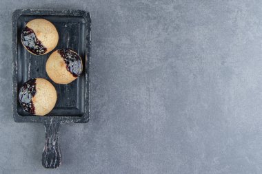 Çikolatalı üç yuvarlak kurabiyeden oluşan koyu tahta bir tahta. Yüksek kalite fotoğraf