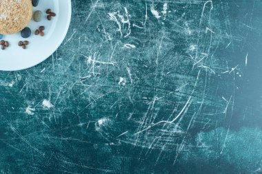 Mavi arka planda sincap keki, şekerleme ve kahve çekirdekleri olan bir tabak. Yüksek kalite fotoğraf