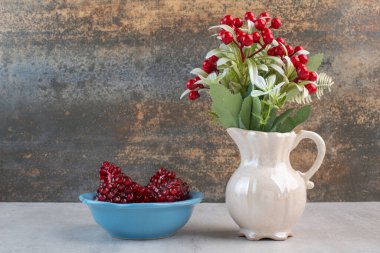 Gri arka planda, içi nar dolu mavi bir tabak. Yüksek kalite fotoğraf