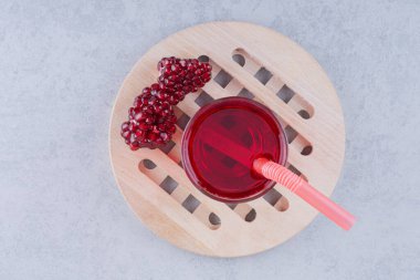 Bir bardak nar suyu samanla ahşap bir parça üzerinde. Yüksek kalite fotoğraf