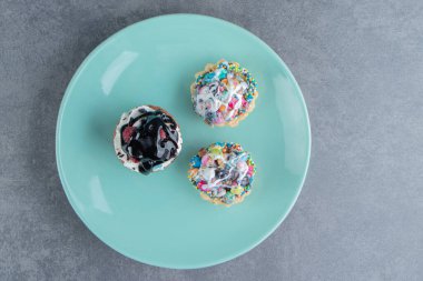 Üç tatlı kekten oluşan mavi bir tabak. Yüksek kalite fotoğraf