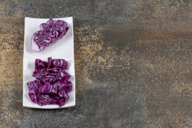 Kabın içinde, mermer arka planda bir lahana parçasının yanında ince ince doğranmış lahana. Yüksek kalite fotoğraf