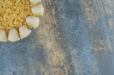 Pişirilmiş pipo ve pişmemiş papyonlu pastalar mermer arka planda. Yüksek kalite fotoğraf