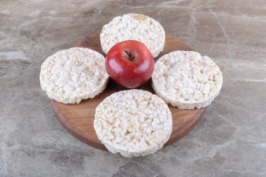 Elma ve pirinç kekleri ahşap tepside, mermer arka planda. Yüksek kalite fotoğraf