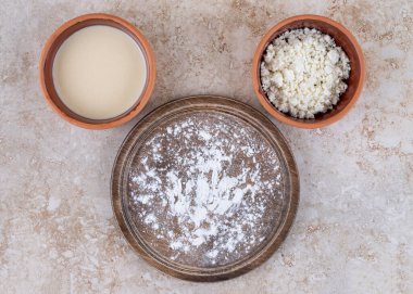 Kahverengi bir tabak un ve bir kase süzme peynir. Yüksek kalite fotoğraf